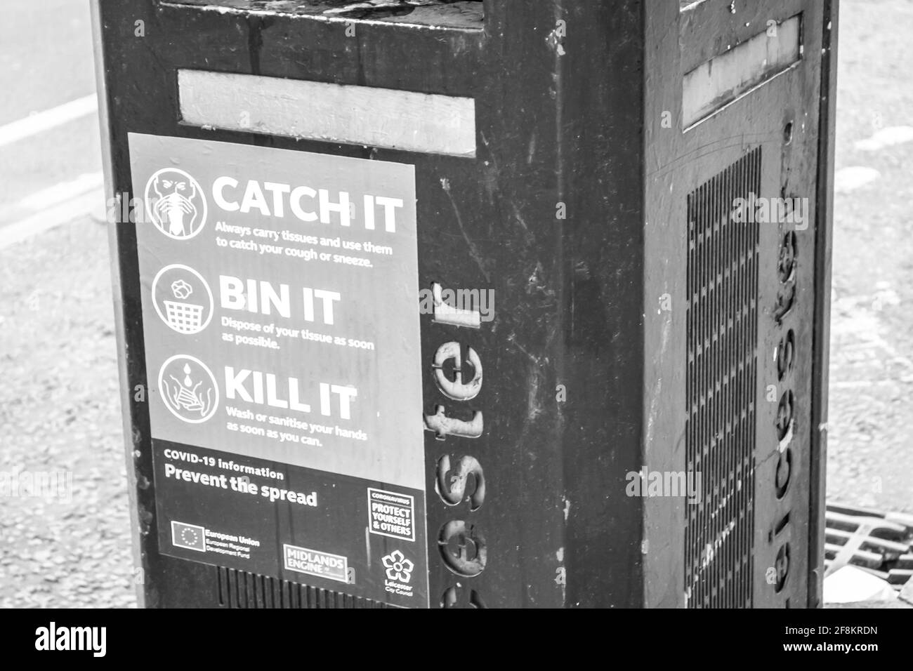 LEICESTER, ENGLAND- 3 April 2021: Litter bin in Leicester city centre with a coronavirus poster amid the pandemic Stock Photo