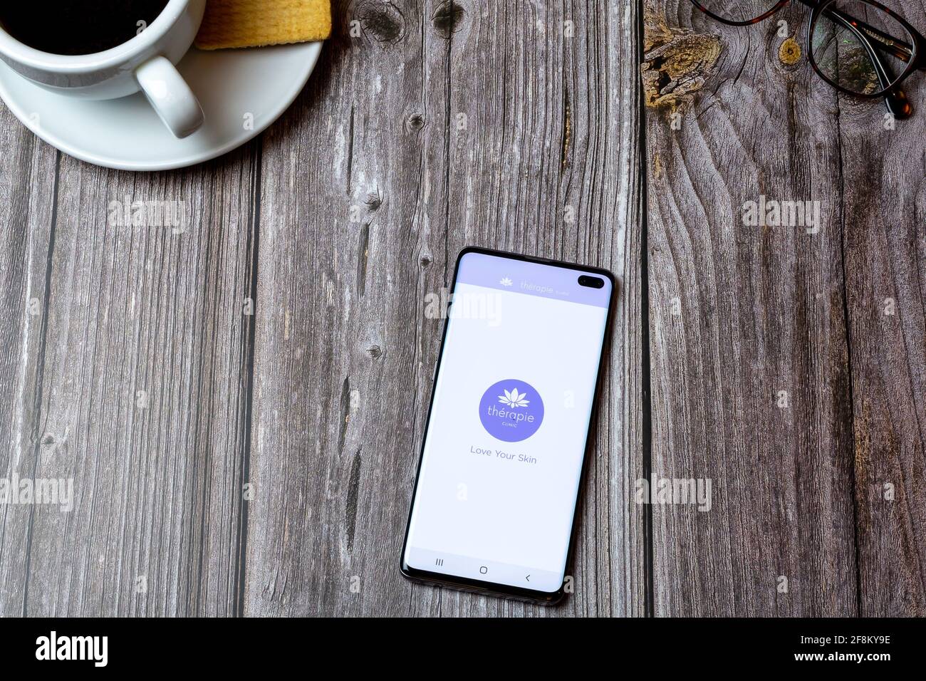 A Mobile phone or cell phone laid on a wooden table showing the ...