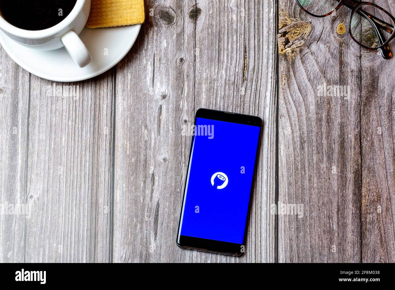 A Mobile phone or cell phone laid on a wooden table showing the