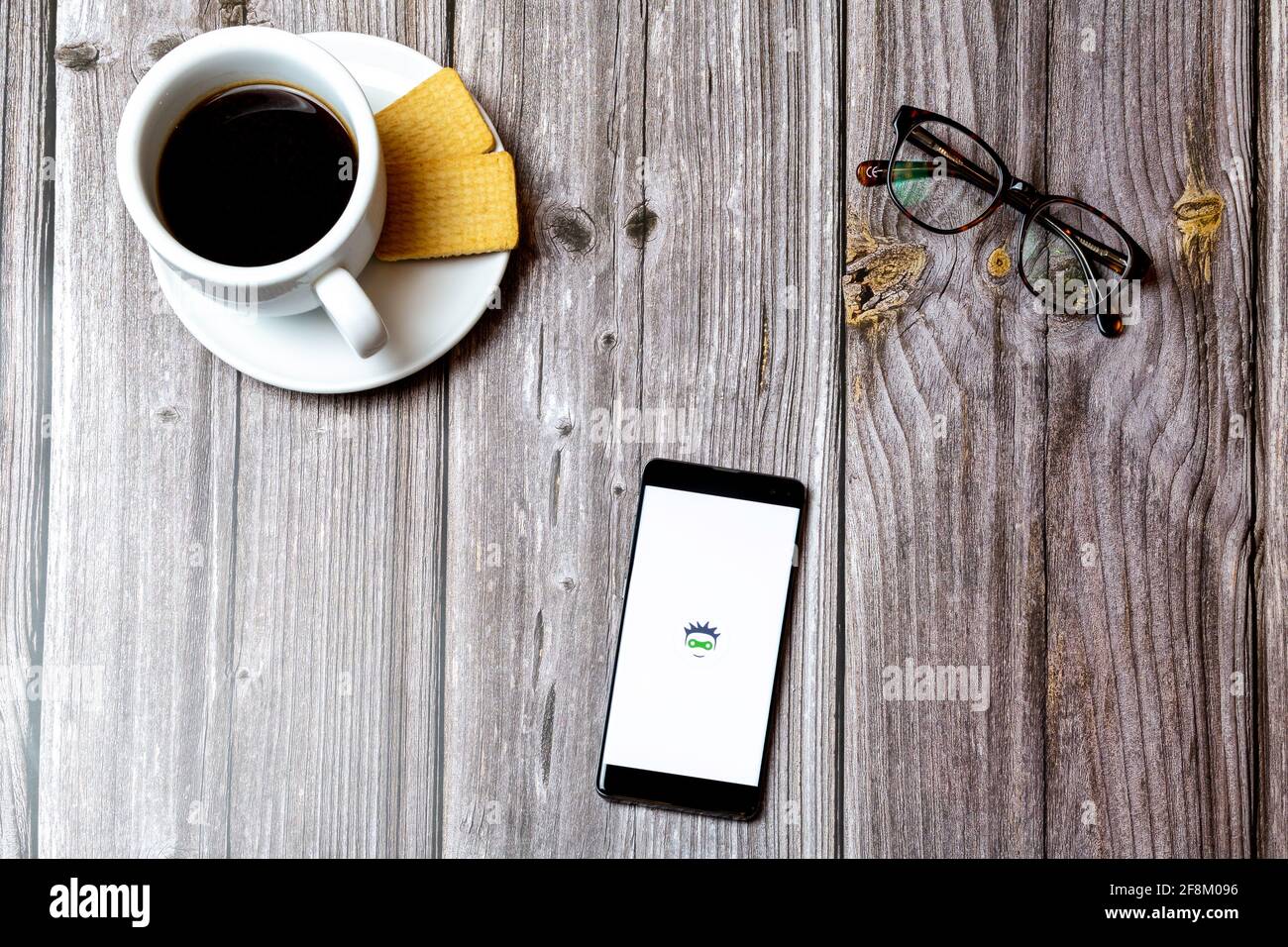 A Mobile phone or cell phone laid on a wooden table showing the cyclers UK app on screen Stock Photo