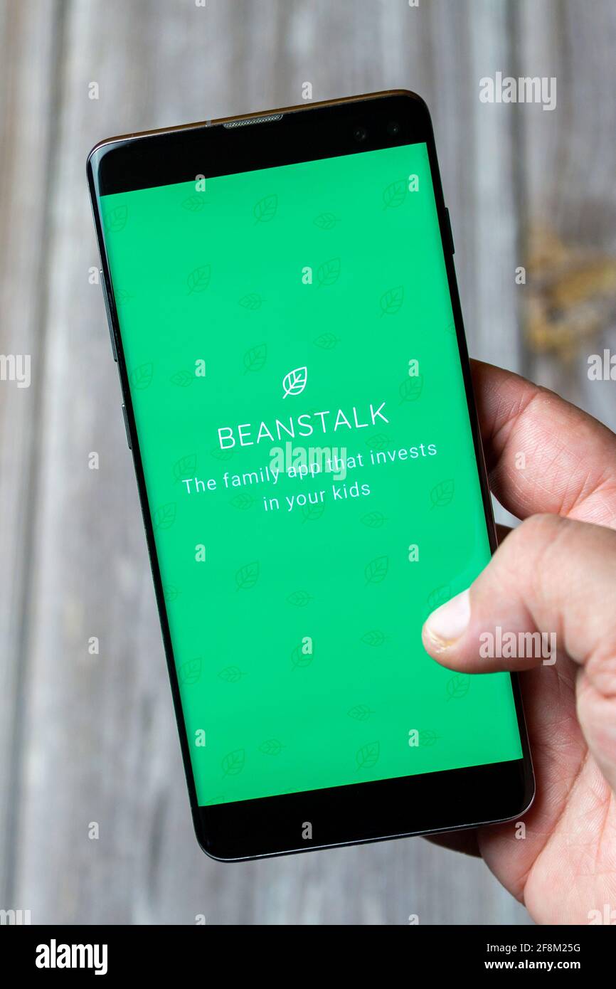 A Mobile phone or Cell phone being held in a hand showing the Beanstalk app on screen Stock Photo