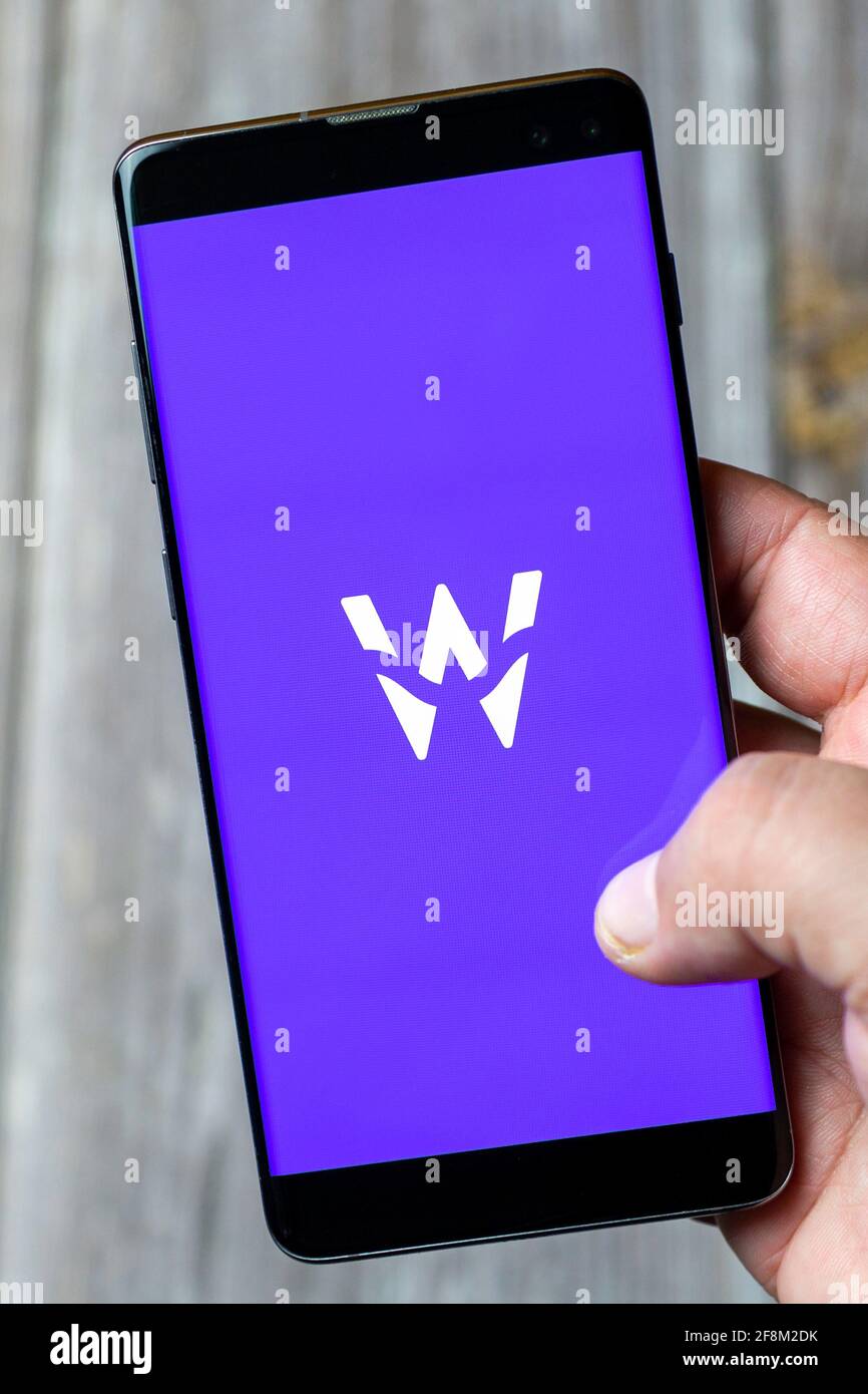 A Mobile phone or Cell phone being held in a hand showing the Wagestream app on screen Stock Photo