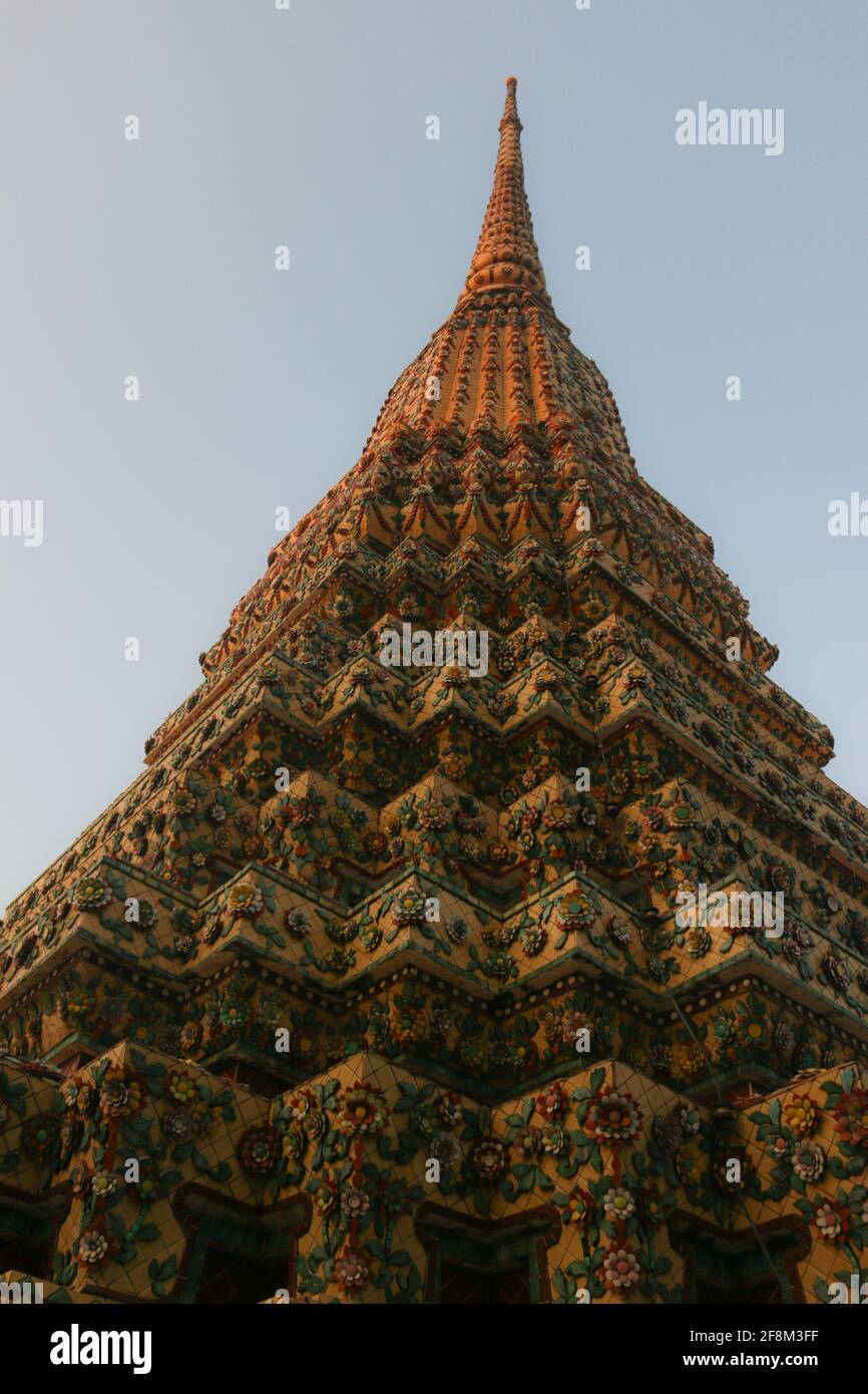 The green mosaic tiled stupa from Rama I reaches symmetrical the clear sky in low angle view. and is one of four pagodas of Phra Chedi Rai at Wat Pho. Stock Photo