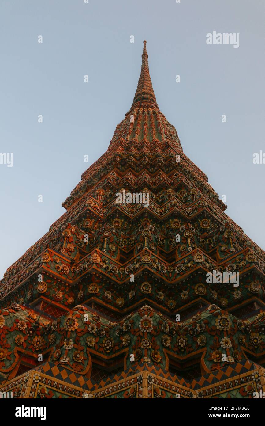 The yellow mosaic tiled stupa from and for Rama I reaches symmetrical the clear sky in low angle view. and is one of four pagodas of Phra Chedi Rai. Stock Photo