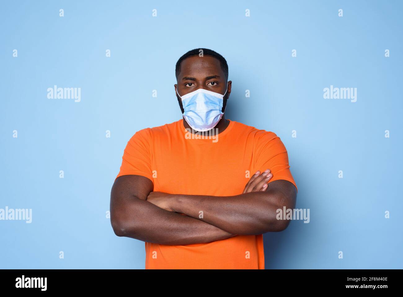 Man with face mask has a lot of questions and doubts about covid 19. cyan background Stock Photo