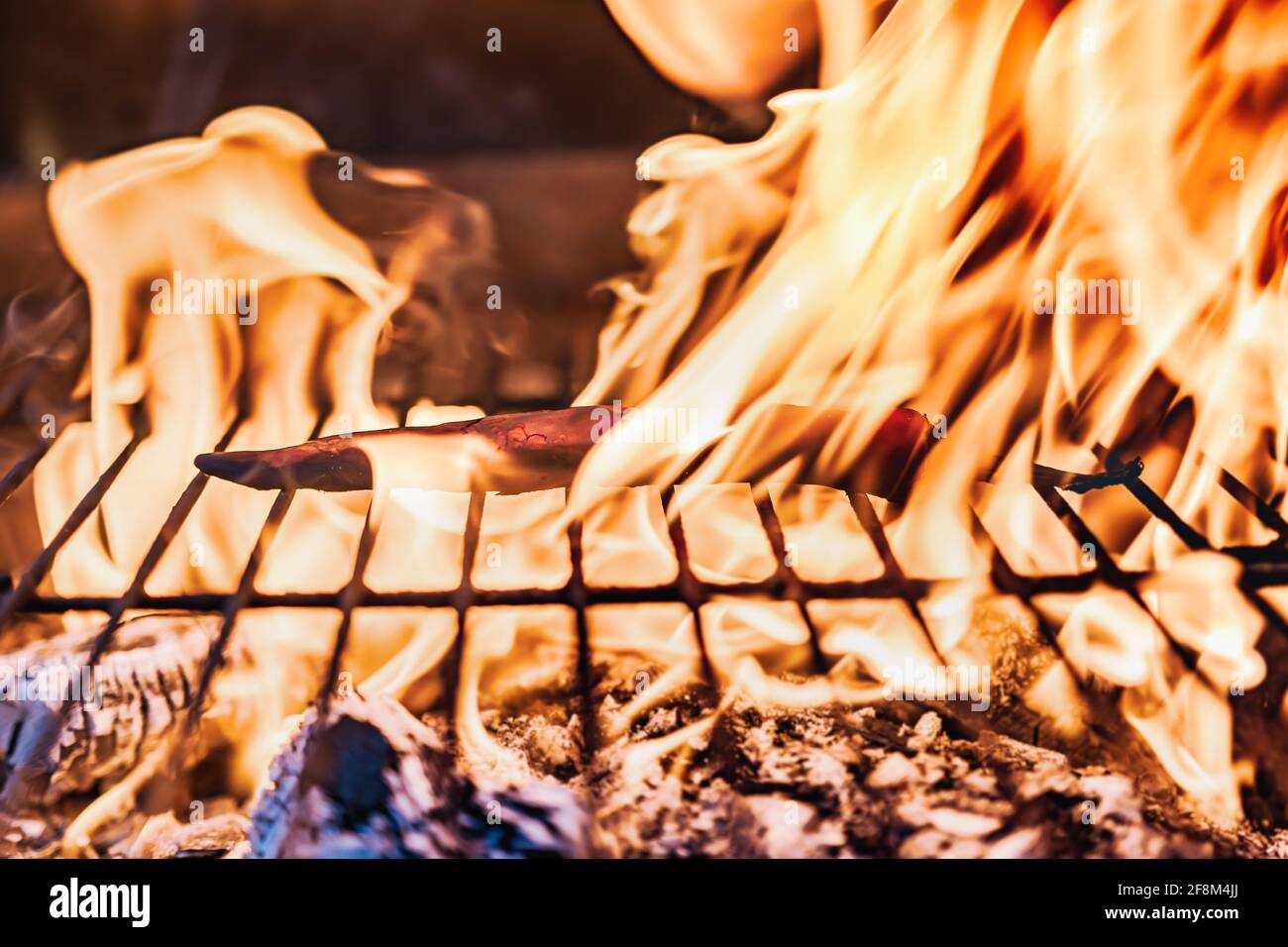 Chilli on a barbecue outdoors with flames from the fire Stock Photo