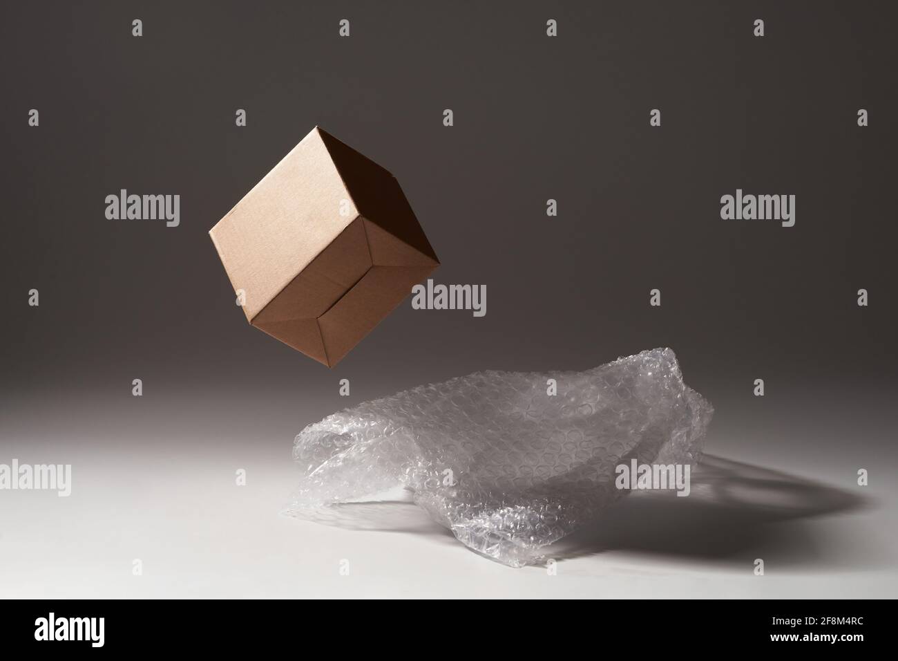 Cardboard box and bubble wrap on dark background Stock Photo