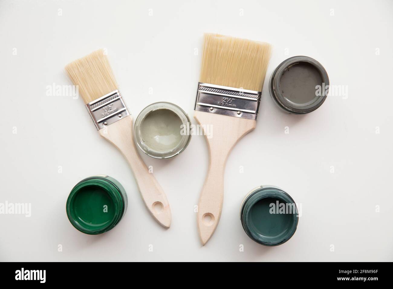 Overhead view of a DIY paint brush with trendy green sample paint pots Stock Photo