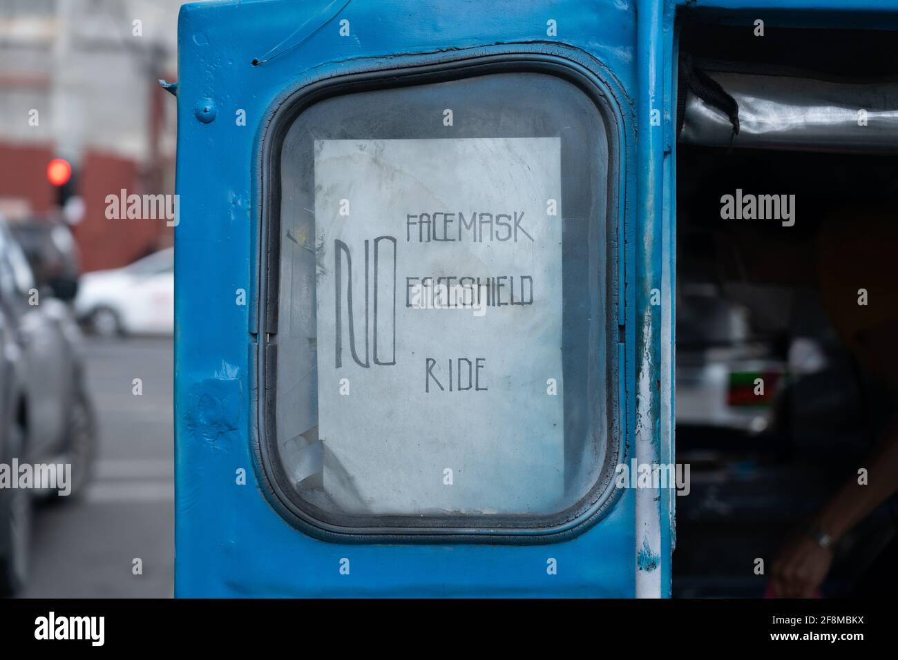 A sign on the rear of a Jeepney vehicle, declaring passengers need a face mask and shield to enter the vehicle which is a requirment for public transp Stock Photo