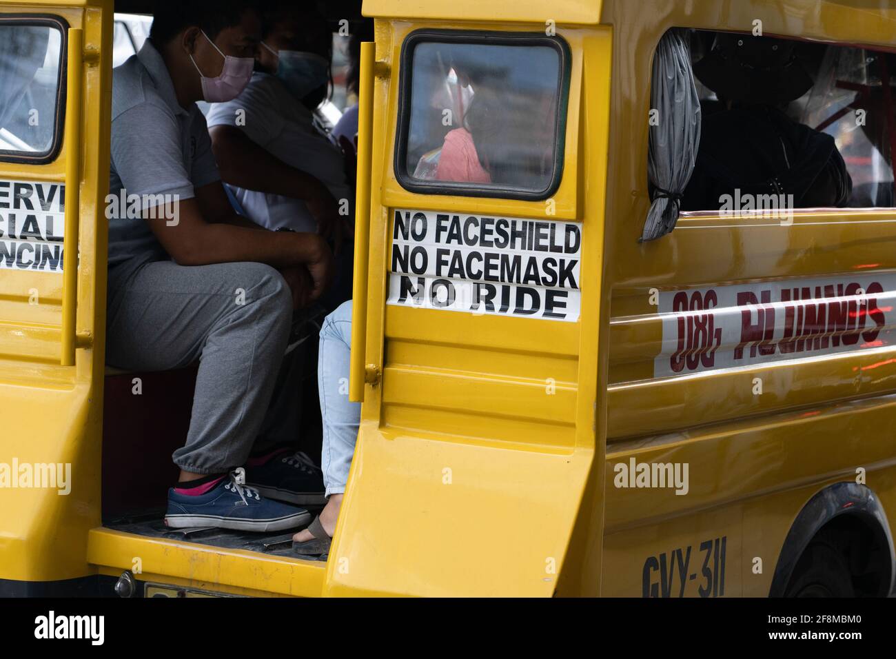 A sign on the rear of a Jeepney vehicle, declaring passengers need a face mask and shield to enter the vehicle which is a requirment for public transp Stock Photo