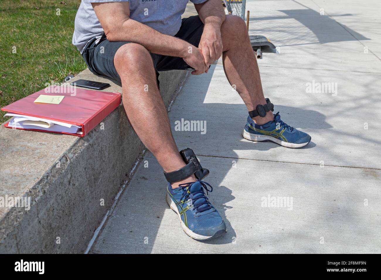 Detroit, Michigan - A man wears an electronic tether on each ankle. The devices report his location to criminal justice authorities. Stock Photo