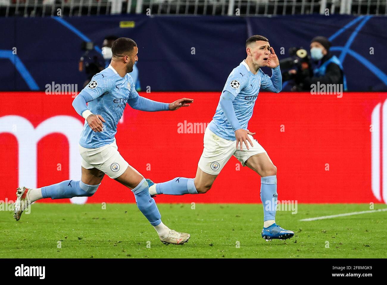 Dortmund, Germany. 14th Apr, 2021. Phil Foden (R) of Manchester City celebrates after scoring during a UEFA Champions League quarterfinal second leg match between Borussia Dortmund and Manchester City in Dortmund, Germany, April 14, 2021. Credit: Joachim Bywaletz/Xinhua/Alamy Live News Stock Photo