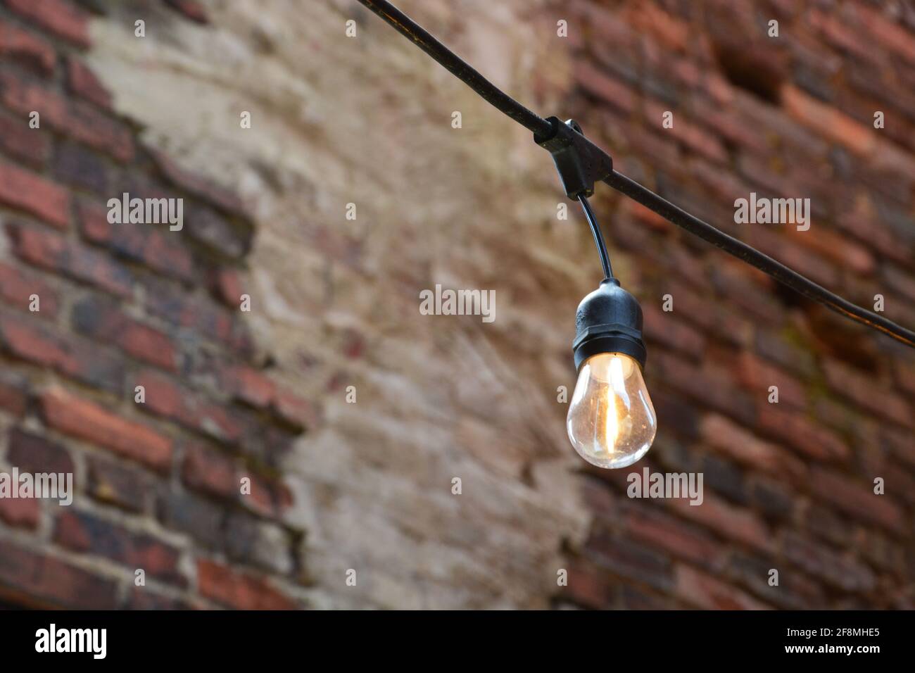 Close up of a party light against a brick wall. Stock Photo