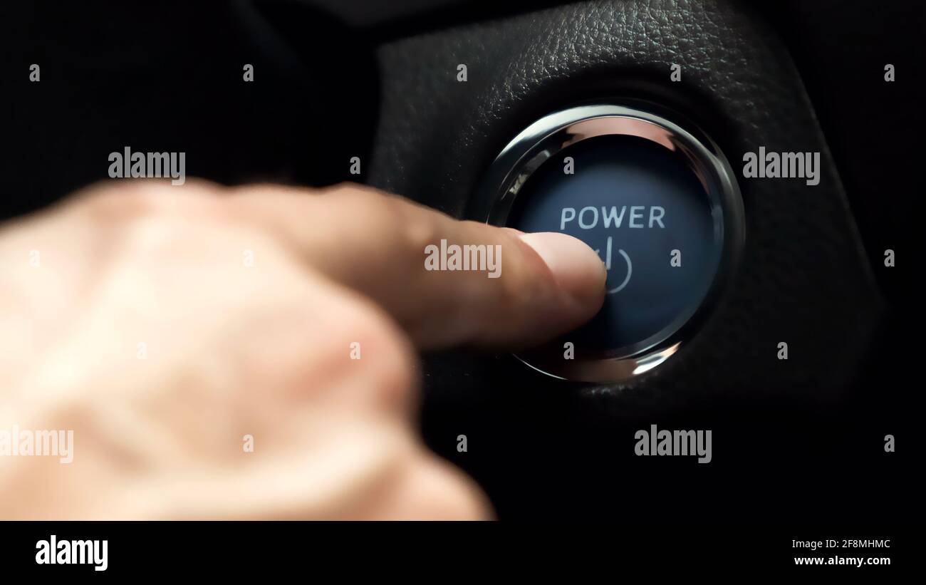 pushing blue  power ignition button to start keyless ignition hybrid car engine Stock Photo