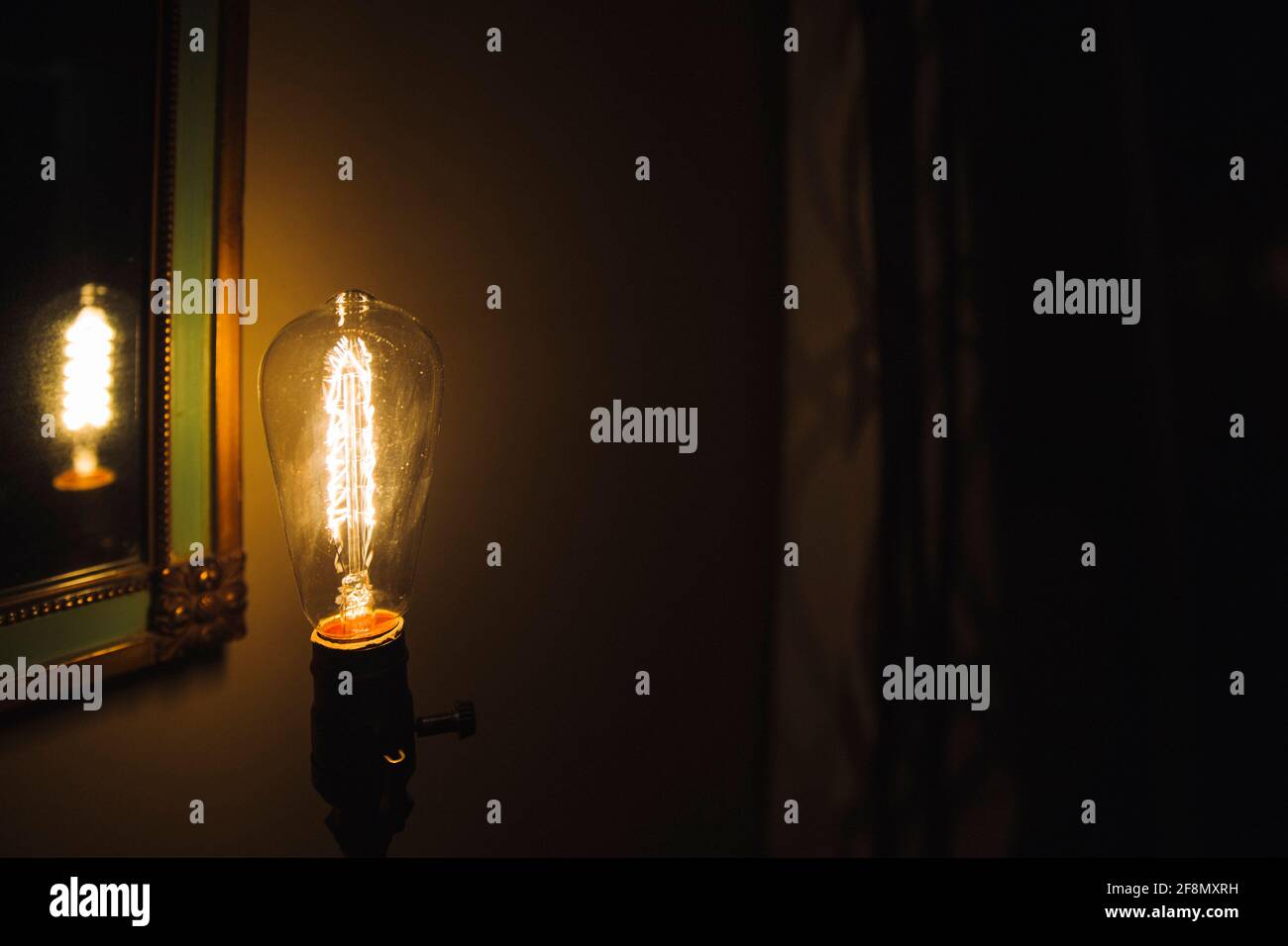 Incandescent bulb. Vintage hanging Edison light bulb in a dark, spooky