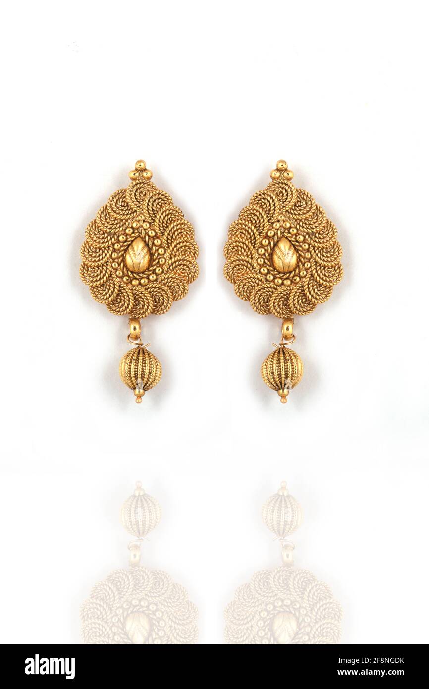 Beautiful Golden pair of earrings on white background Indian traditional jewellery, kundan earrings, Bridal Gold earrings wedding jewellery Stock Photo