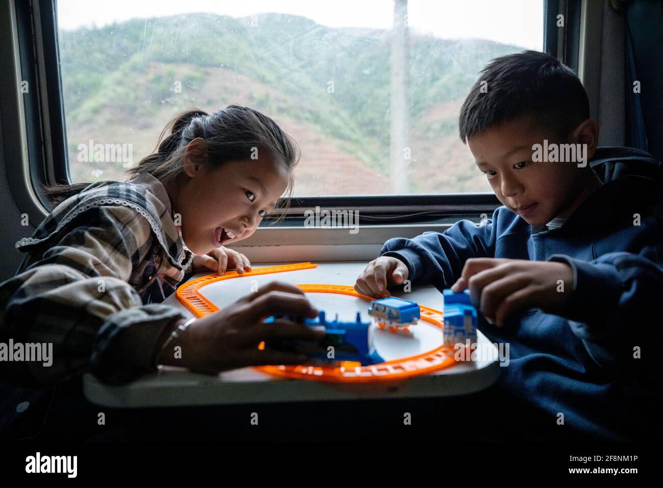 (210415) -- XICHANG, April 15, 2021 (Xinhua) -- Students take the 5633 train to school in southwest China's Sichuan Province, April 11, 2021. As modern high-speed trains shoot past new stations throughout China, a pair of slow-speed trains still run through Daliang Mountains. The 5633/5634 trains run between Puxiong and Panzhihua of Sichuan Province with an average speed less than 40 km per hour. The journey with 26 stations in between takes eleven hours and four minutes, with the ticket prices ranging from 2 yuan to 25.5 yuan(about 0.3-3.9 U.S. dollars). The slow-speed trains send childr Stock Photo
