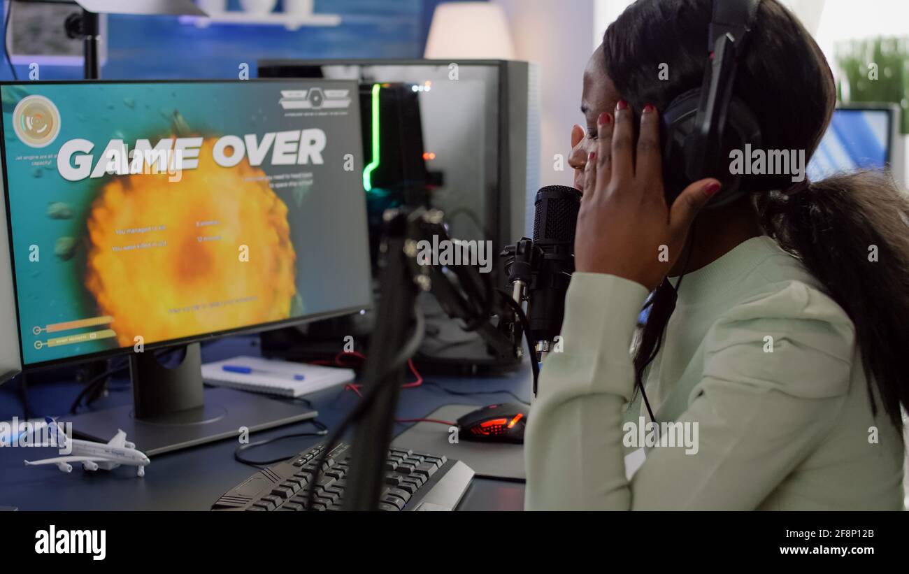 Man gamer teaching his girlfriend playing space shooter video game on RGB  powerful personal computer. Pro cyber woman with headset performing video  games streaming from home during online tournament Stock Photo 