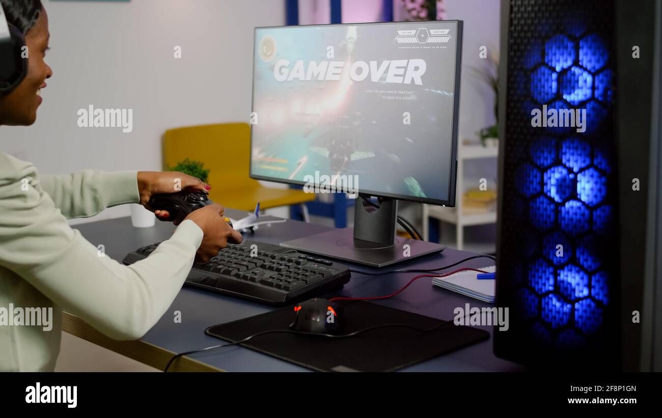 Man gamer teaching his girlfriend playing space shooter video game on RGB  powerful personal computer. Pro cyber woman with headset performing video  games streaming from home during online tournament Stock Photo 