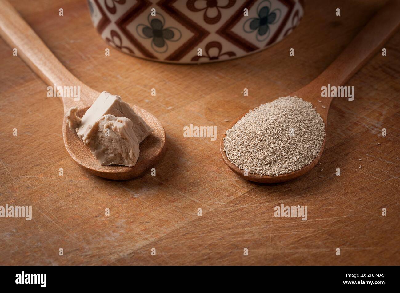 Teaspoon of fresh yeast and instant dry yeast on wooden on a wood cutting board Stock Photo