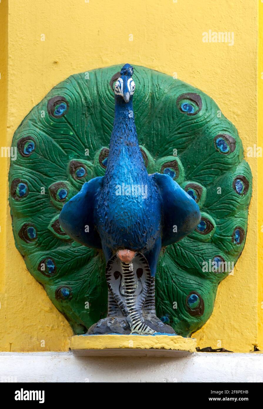 A peacock statue stands adjacent to the main entrance to the Kataragama