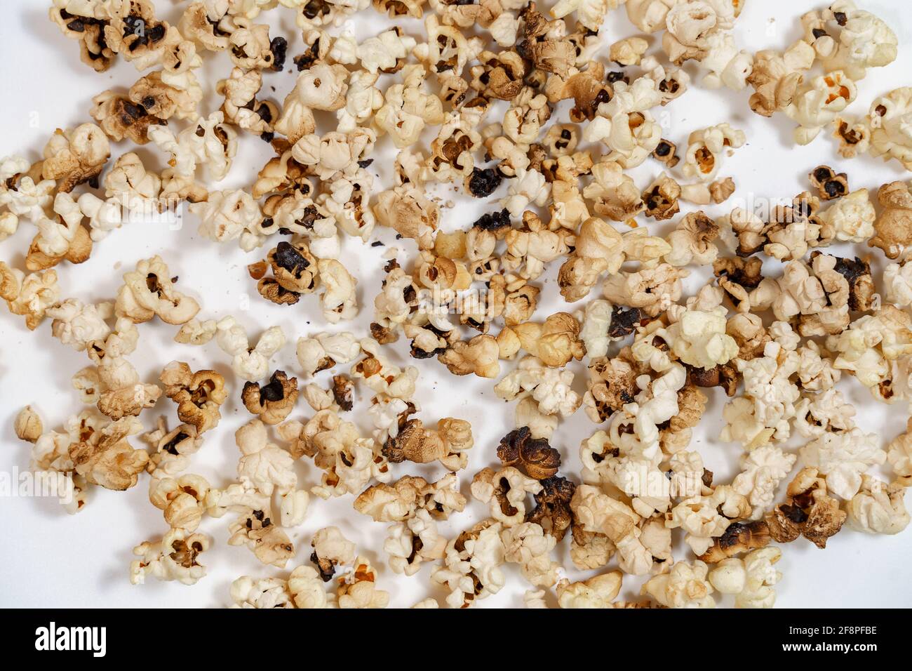 spoiled burnt grains of popcorn close-up. Stock Photo