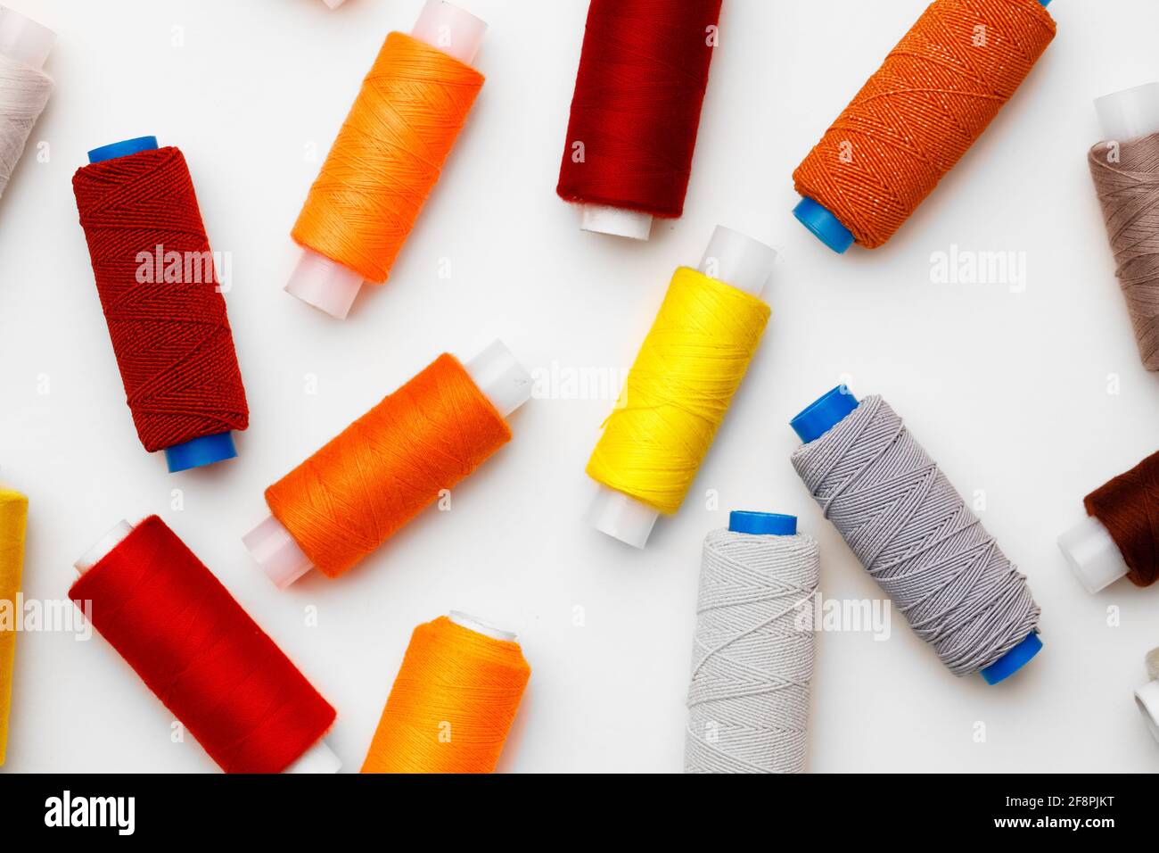 Colored spools of threads on white background Stock Photo - Alamy
