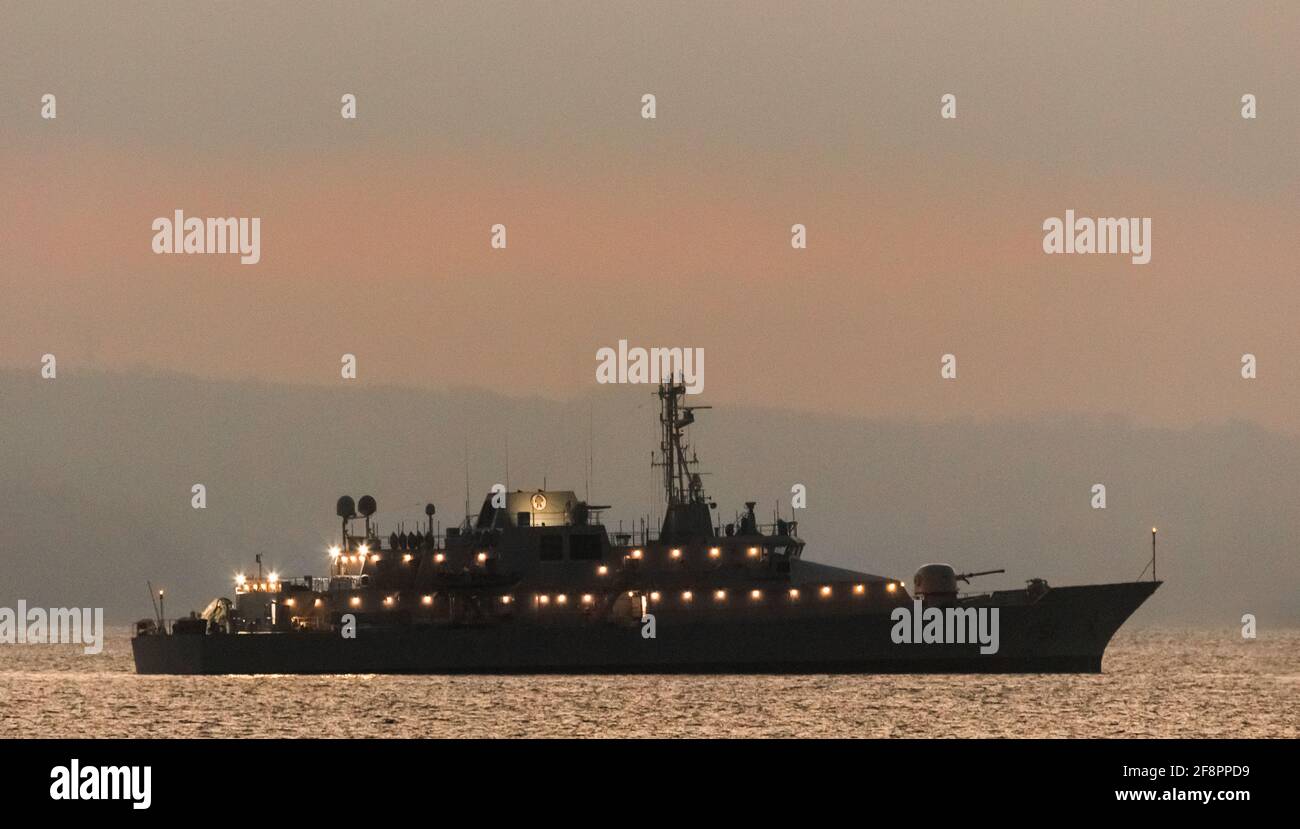 Cork Harbour, Cork, Ireland. 15th April, 2021.  After undergoing a major mid-life refit, naval vessel  LÉ Róisín is undergoing sea trials off the coast before she returns to duty. Picture shows her silhouetted while at anchor before dawn in Cork Harbour, Ireland. - Credit; David Creedon / Alamy Live News Stock Photo