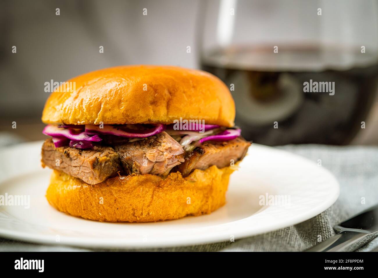 Brisket Slider Sandwich Bun on White Plate Red Wine Dinner Lunch