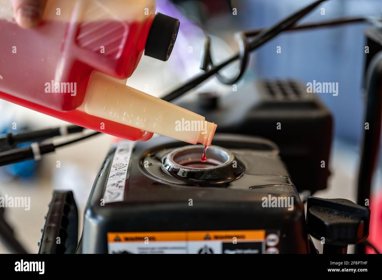 Open gas tank with stabilizer fuel additive being put in before storage
