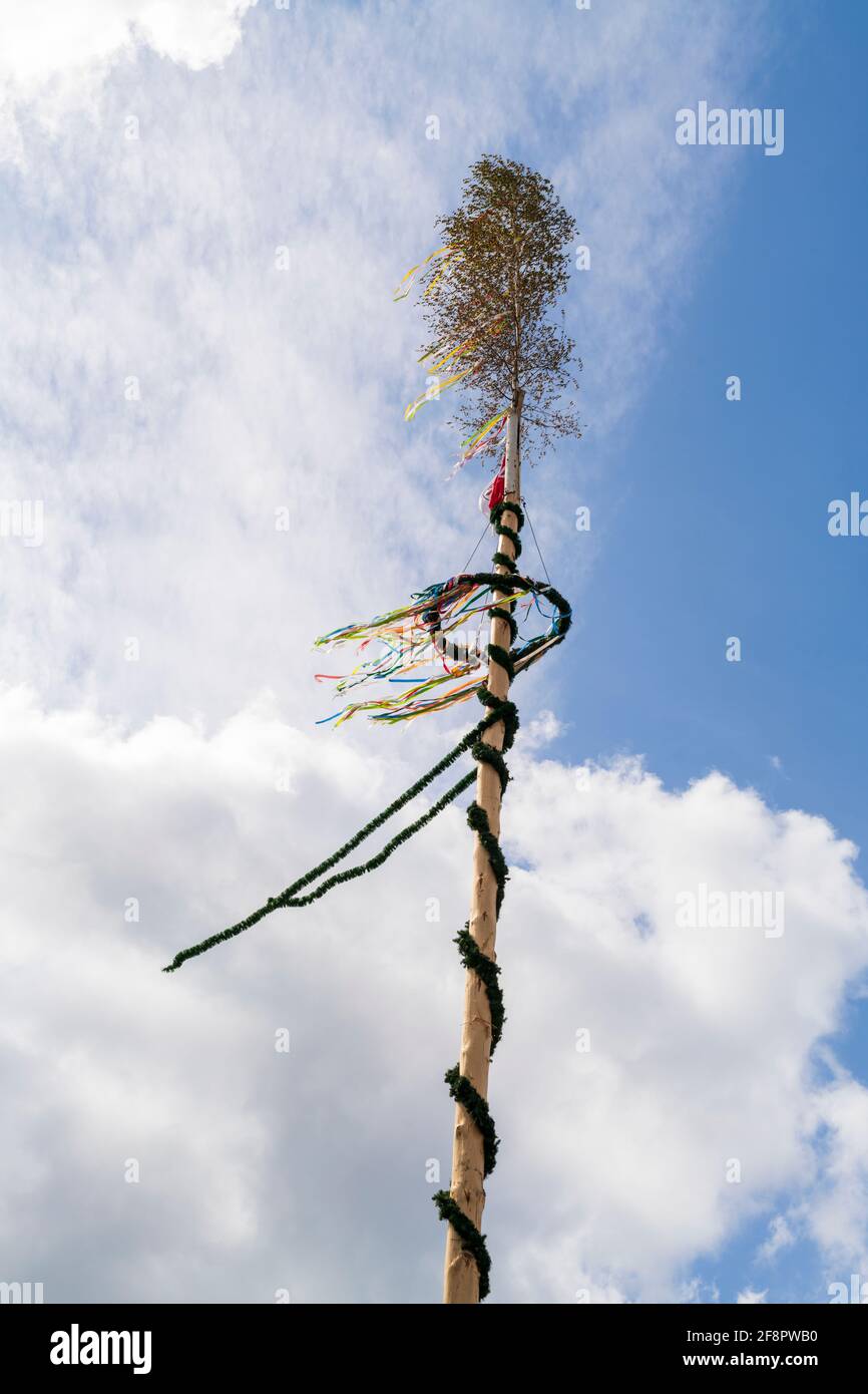 A maypole against blue sky with clouds Stock Photo
