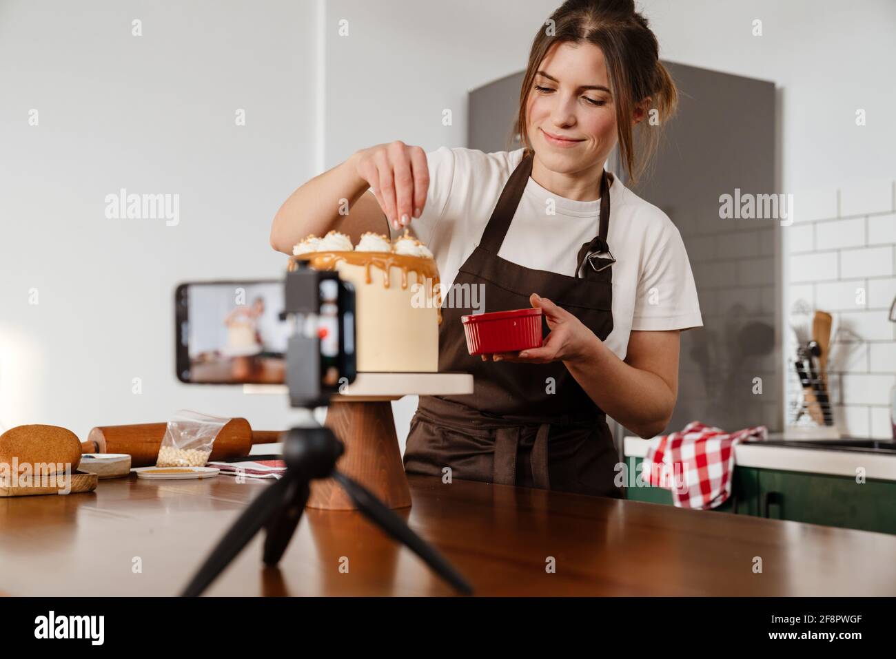 Camera footage of joyful baker woman smiling while making cake with