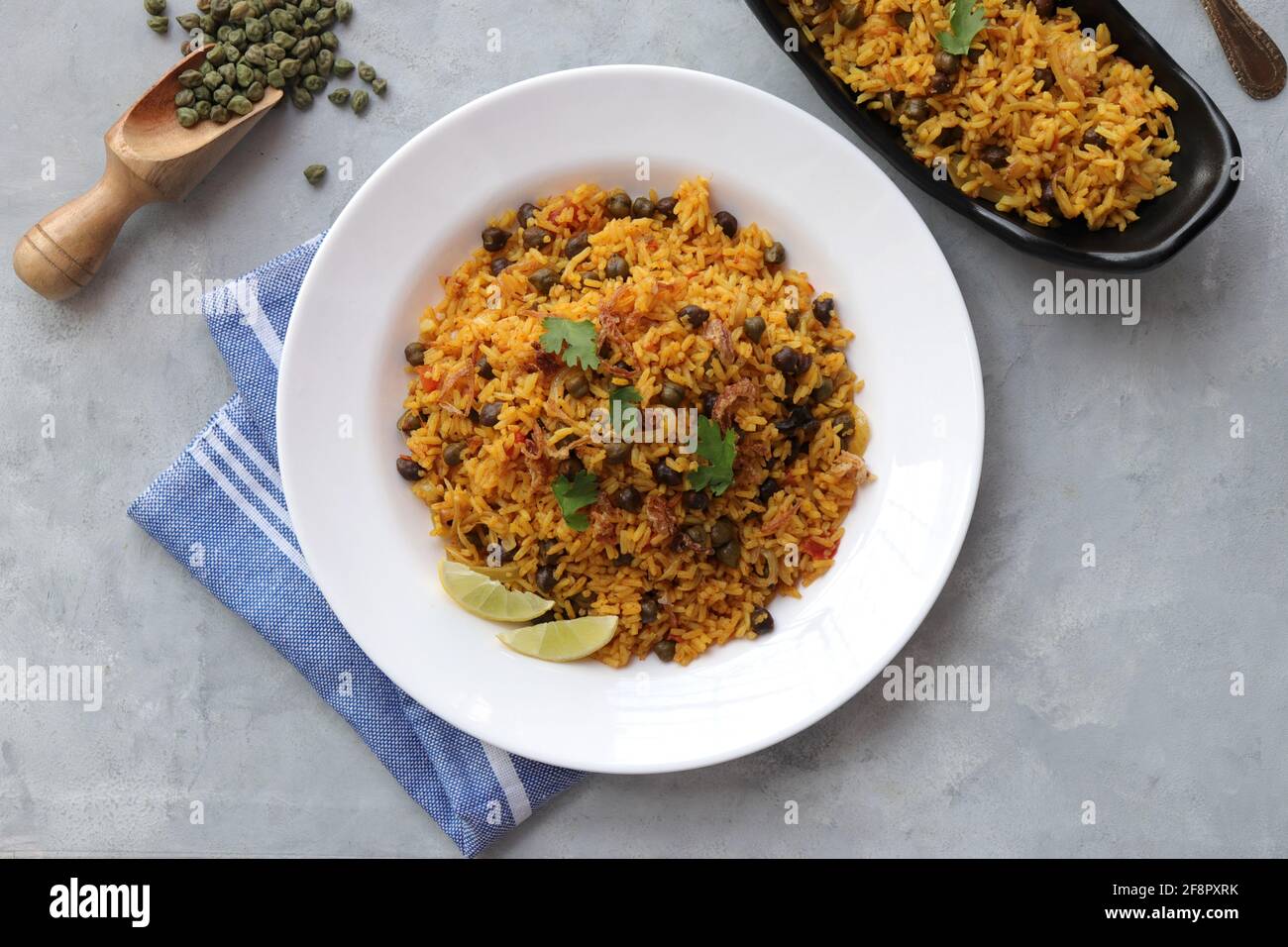 Indian cuisine - Chickpeas Biryani, chole Pulao. Garnished with fried onion, chopped coriander, and lemon wedges. Kala chana biryani. copy space Stock Photo