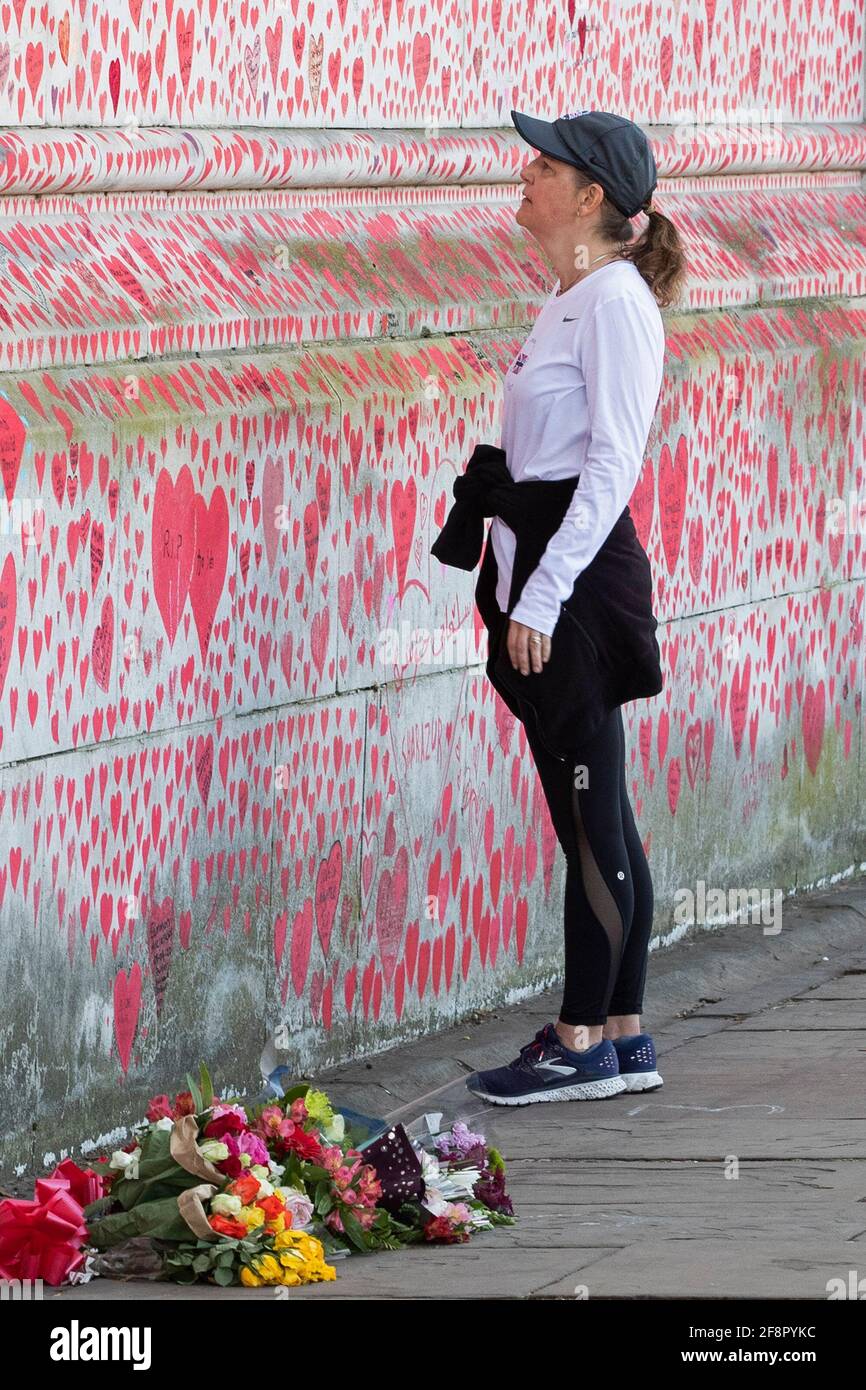 People walk past and write on the national Covid memorial wall, in London on the 9th of April 2021 Stock Photo
