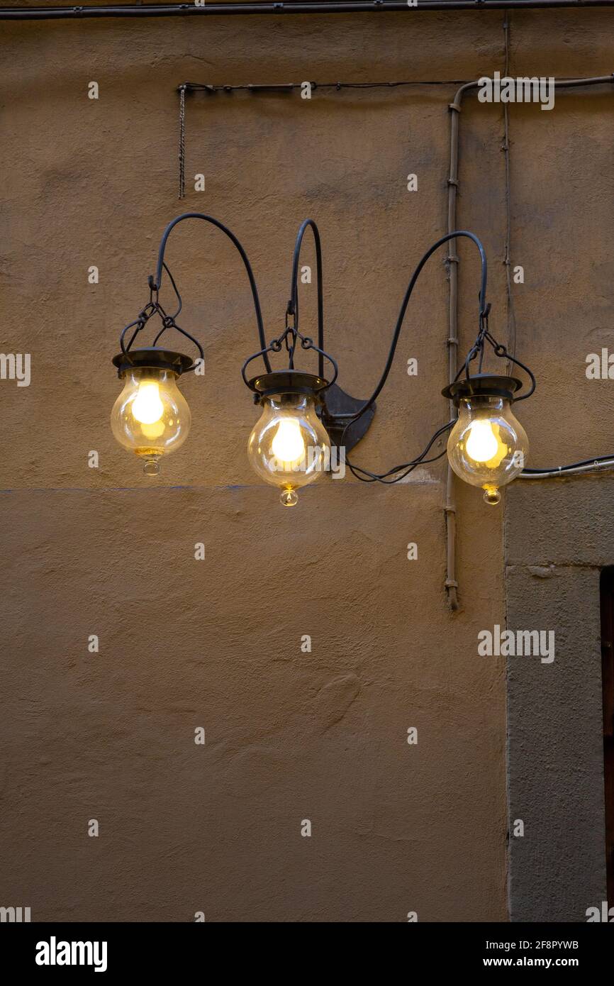 Three Wrought Iron Lights on Exterior Wall Stock Photo
