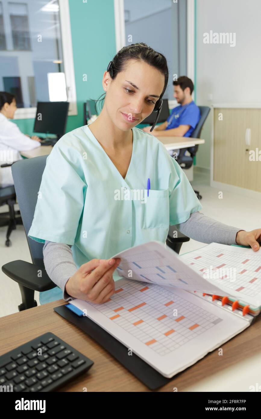 medical secretary looking through folder Stock Photo Alamy