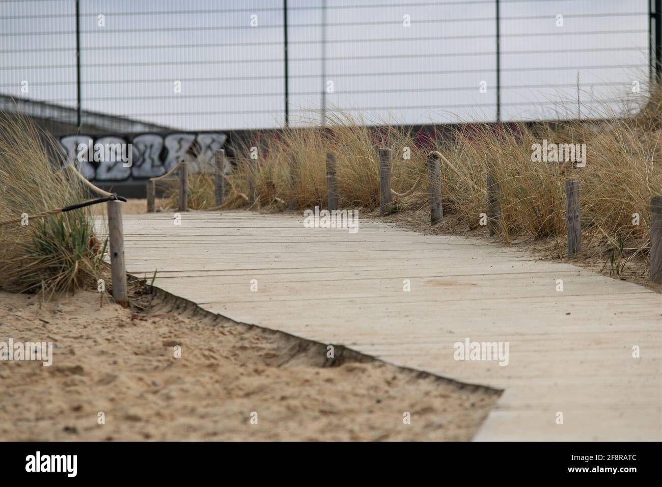 Beach with a wooden path as a closeup on a cold day Stock Photo