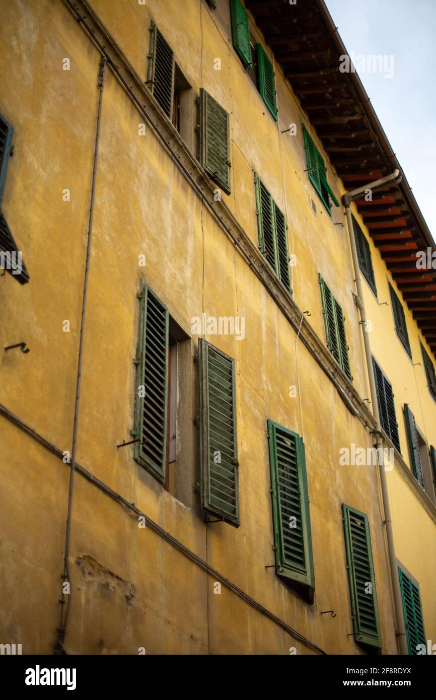 Green-shuttered windows on Yellow Ochre building in Florence, Italy Stock Photo