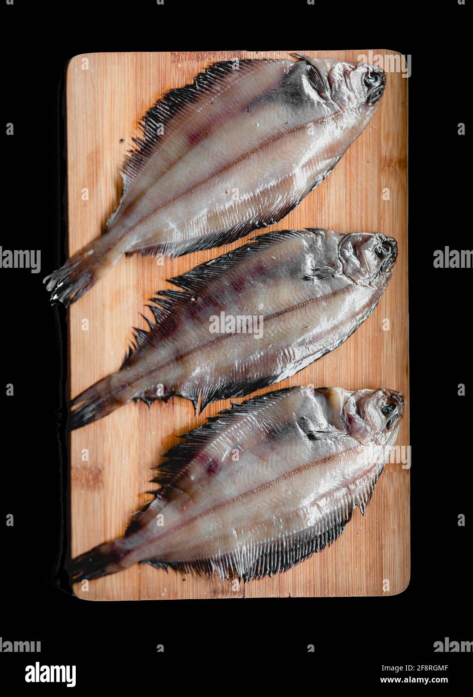 Raw flounder fish, seafood on a wooden cutting Board . Healthy eating concept. Top view Stock Photo
