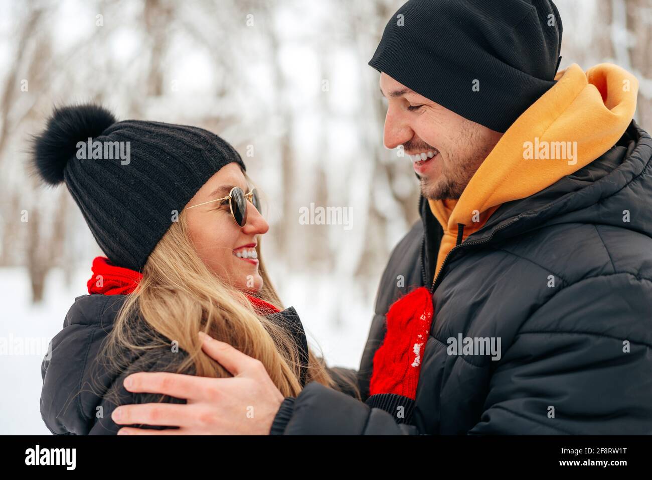 Happy couple hugging and smiling outdoors in snowy park Stock Photo - Alamy