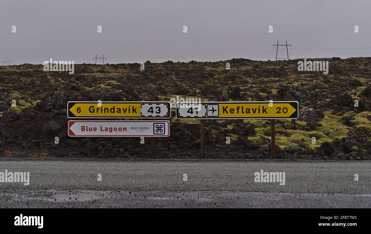 Directional signs at junction of rural road between lava fields showing the direction to tourist resort Blue Lagoon, Grindavik village and to Keflavík. Stock Photo