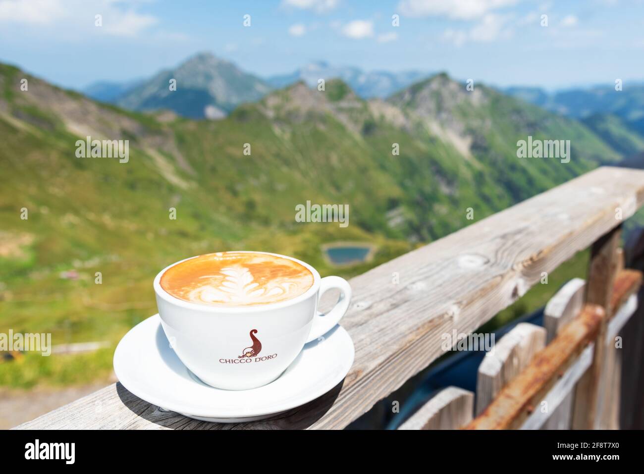 Hot coffee in cup of Chicco d'oro on terrace with beautiful view