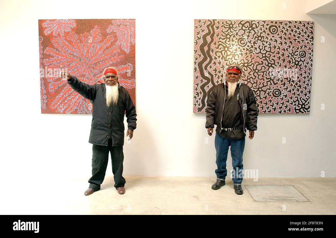 L-R SIMON HOGAN AND ROY UNDERWOOD OF THE SINIFEX PEOPLE IN AUSTRALIA IN FROUNT OF THEIR PAINTINGS WHICH DEPICT STORIES OF THE CREATION OF THE EMU,ON SHOW AT THE REBECCA HOSSACK GALLERY, LONDON W1. 10 May 2005 TOM PILSTON Stock Photo