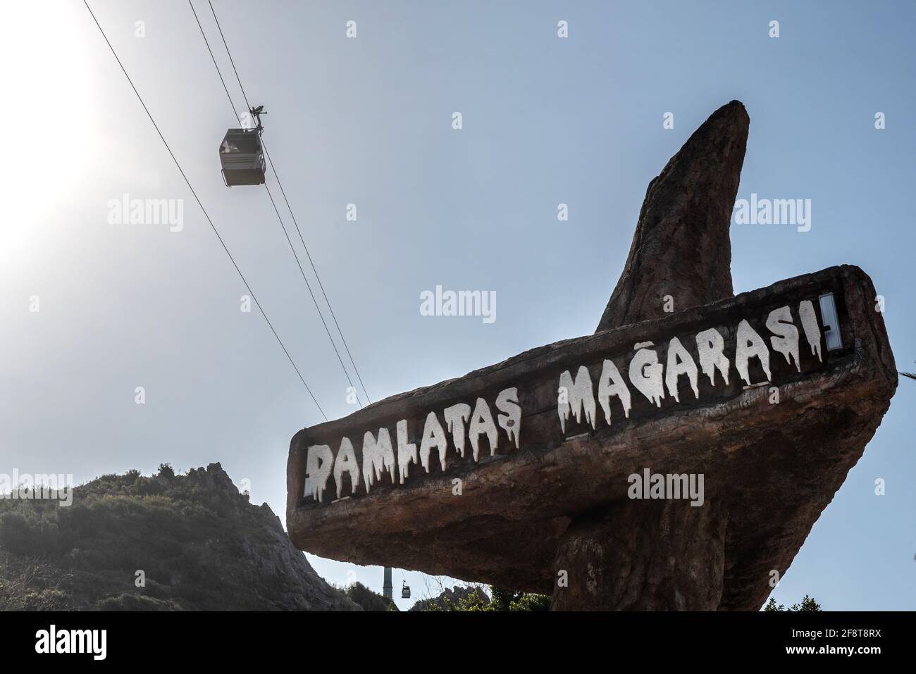Alanya, Turkey. April 7th 2021 Entrance to Damlatas Magarasi with a cable car passing by. The cave and Teleferic are tourist attractions in the Turkis Stock Photo