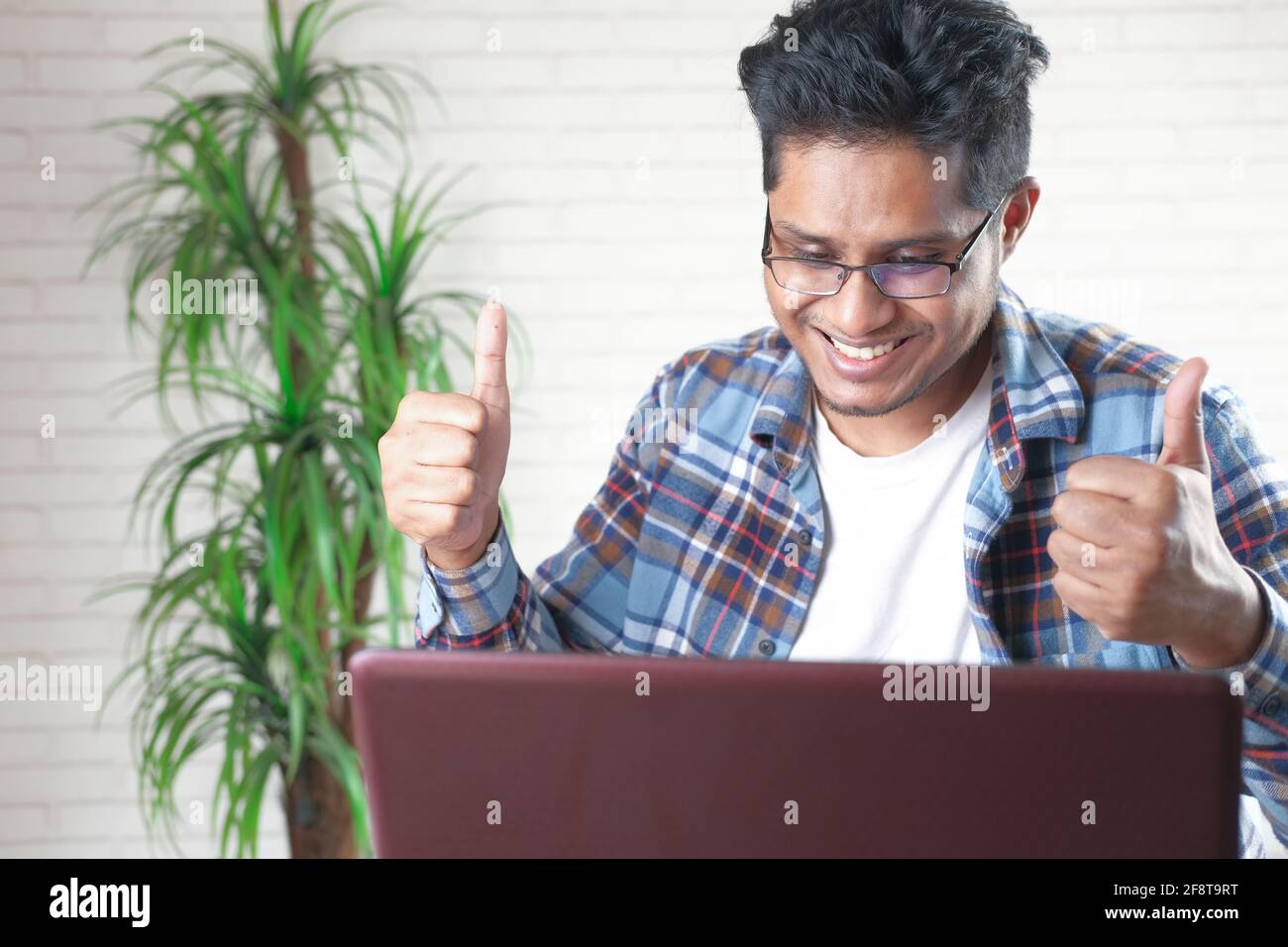 happy young asian man working on laptop with copy space  Stock Photo