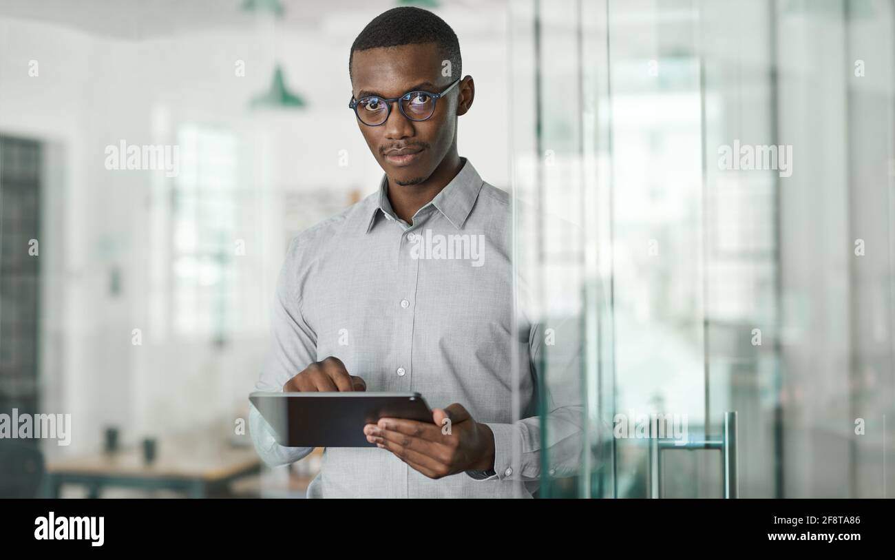 Confident young African businessman using a digital tablet at work Stock Photo