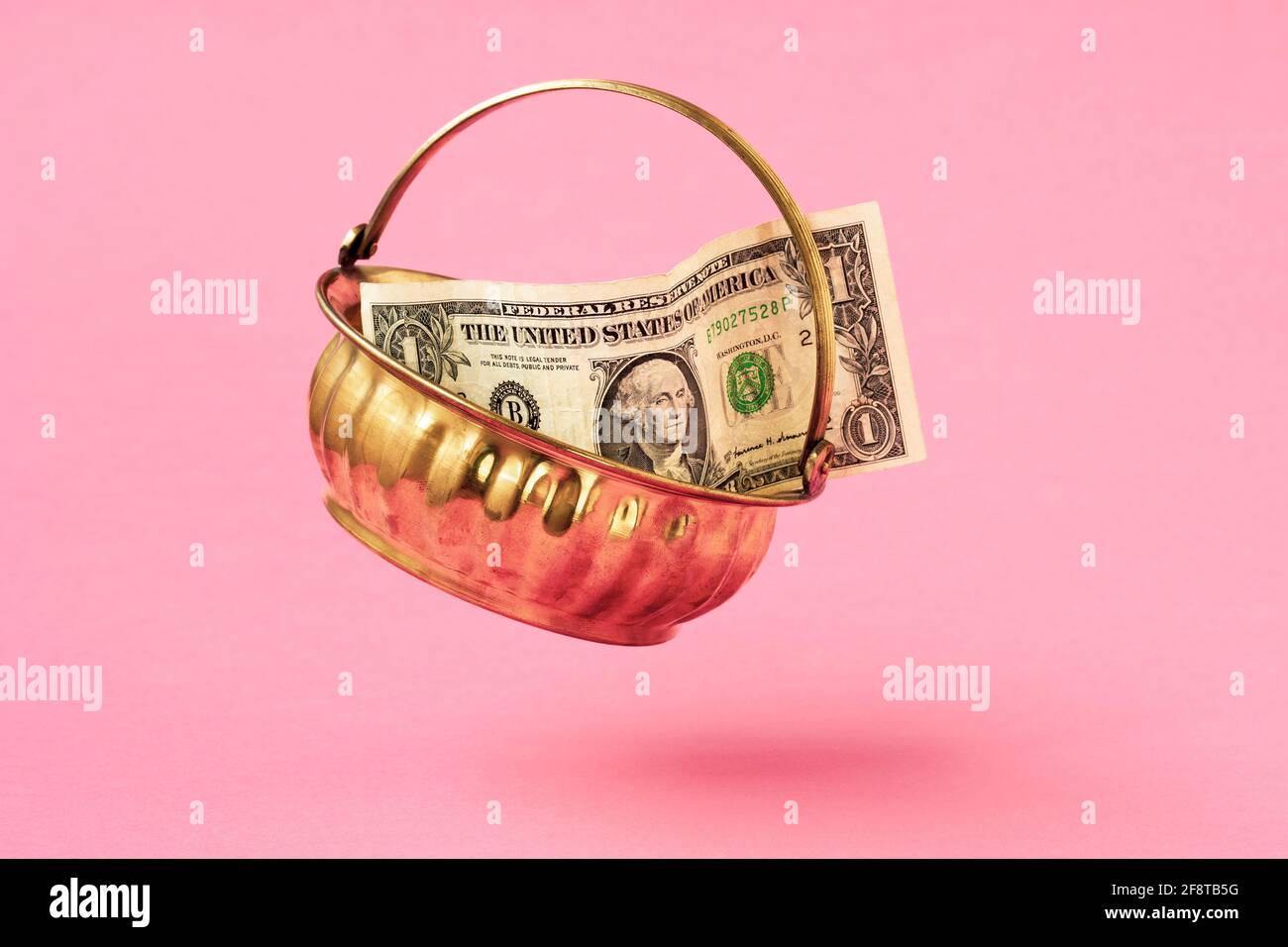 golden-pot-with-one-dollar-falling-on-pink-background-stock-photo-alamy