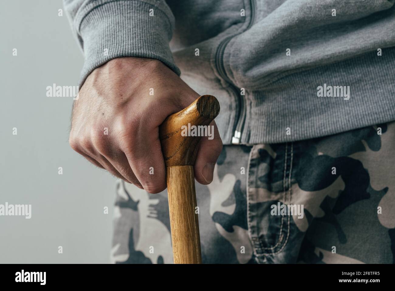 Man holding walking stick, close up of hand with selective focus Stock Photo