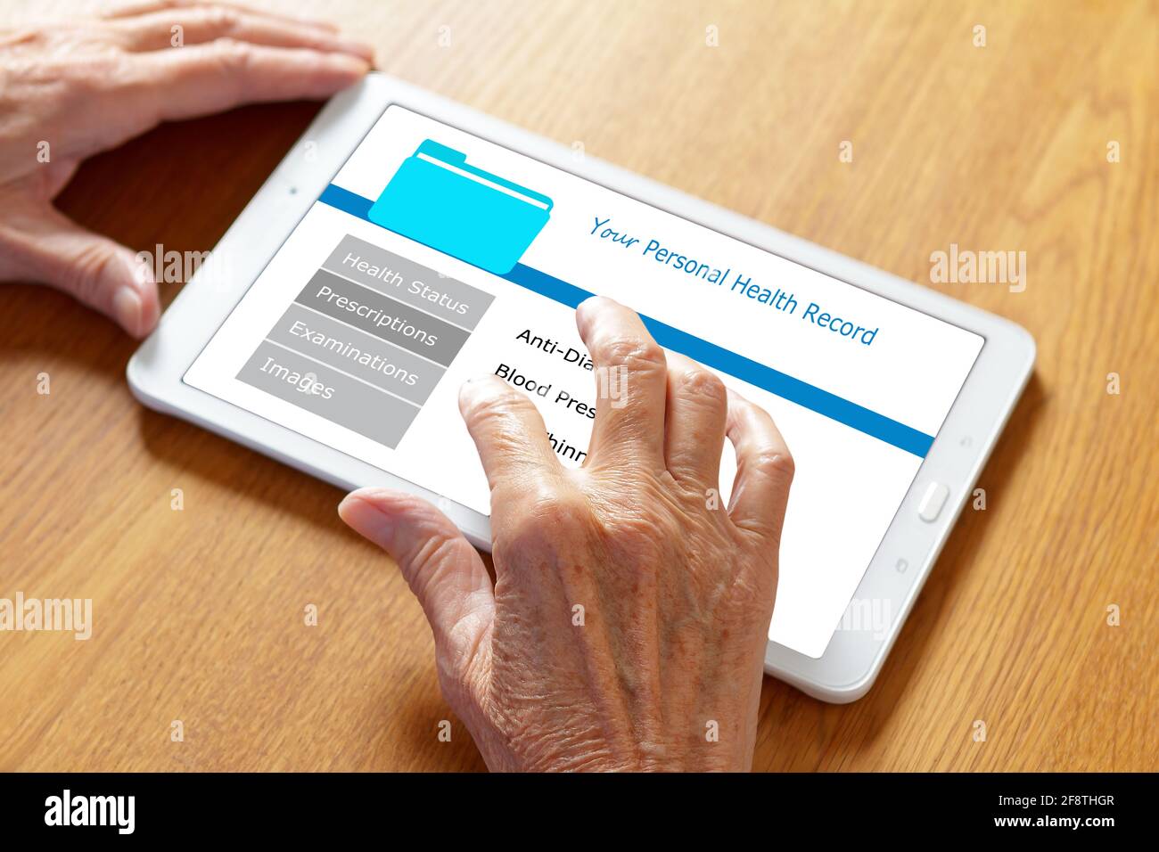 Mobile health concept: personal patient record on a tablet computer, hands of an old woman touching the screen. Stock Photo