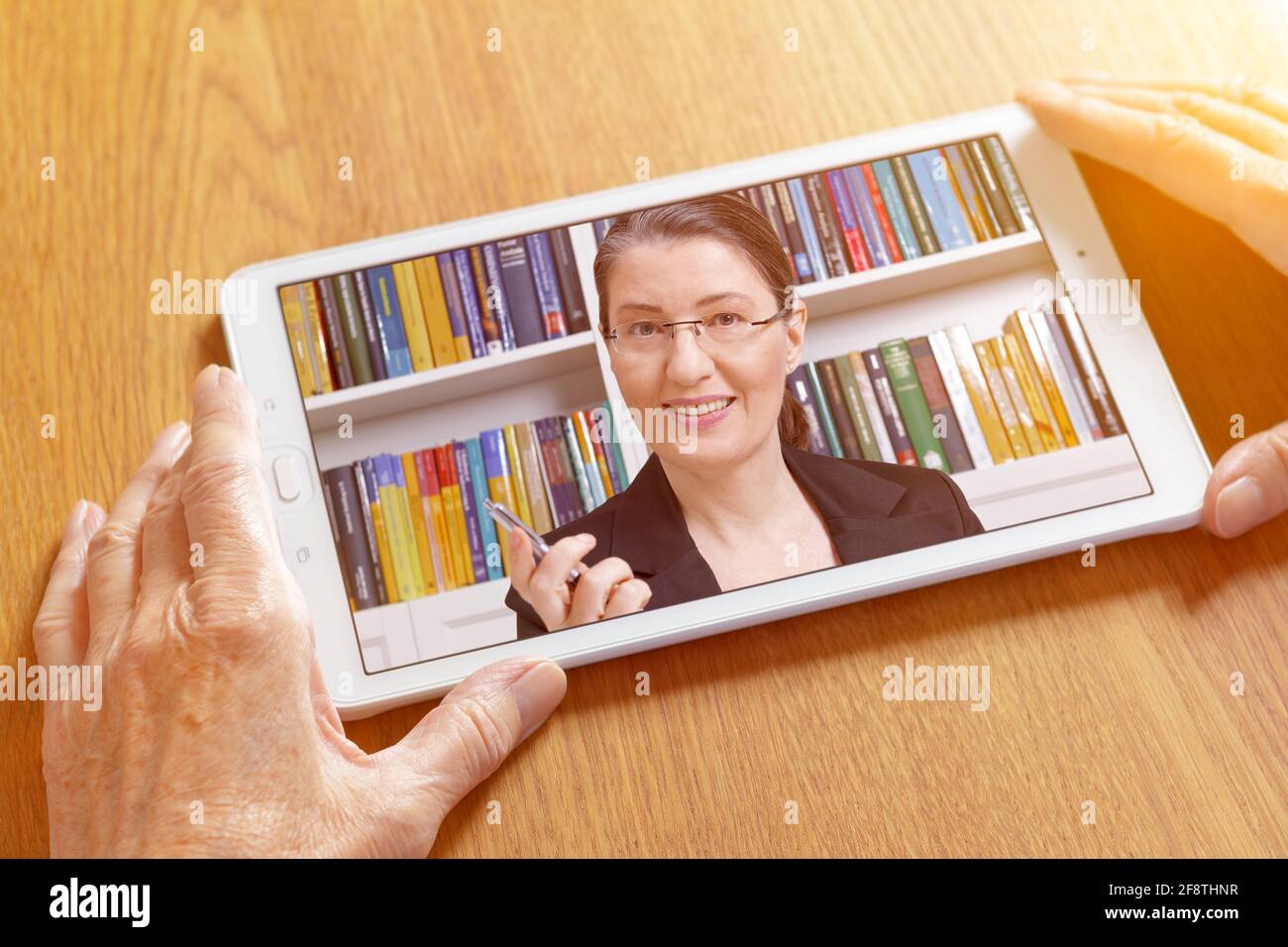 Teletherapy or online counseling concept: friendly middle aged woman talking on a tablet pc in the hands of an elderly woman. Stock Photo